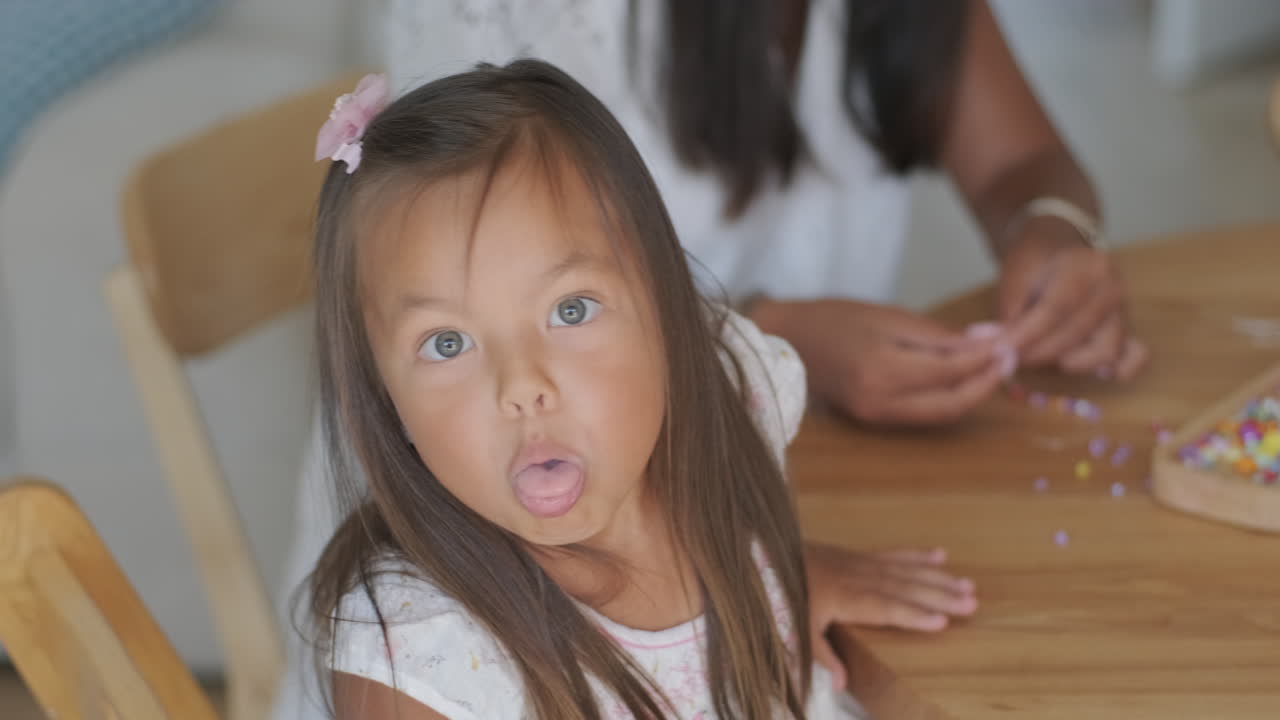 작은 소녀가 구슬로 놀고 있다