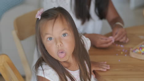 niña jugando con cuentas.
