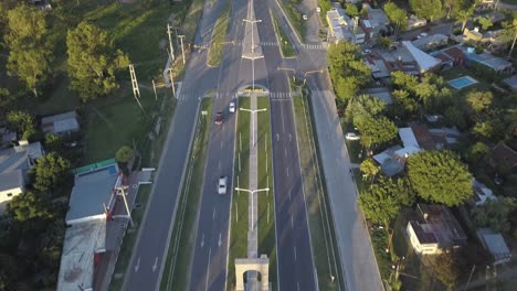 aerial view of suburban road traffic on sunny morning, san jose del ricon, santa fe, argentina, tilt up drone shot