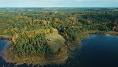 peaceful lake and vibrant autumn forest from above - drone footage from central europe poland