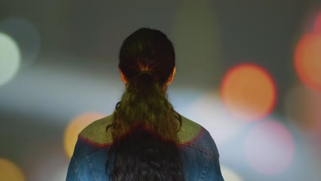 벽 1에 모양과 패턴을 투사하는 몰입 예술 전시회를 방문하는 여성
