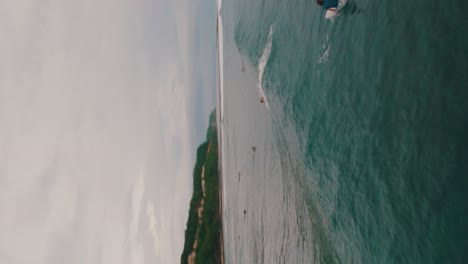 Vista-Aérea-Vertical-De-Los-Surfistas-Navegando-En-La-Playa-De-Green-Bowl-En-Bali