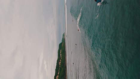 vista aérea vertical de los surfistas navegando en la playa de green bowl en bali