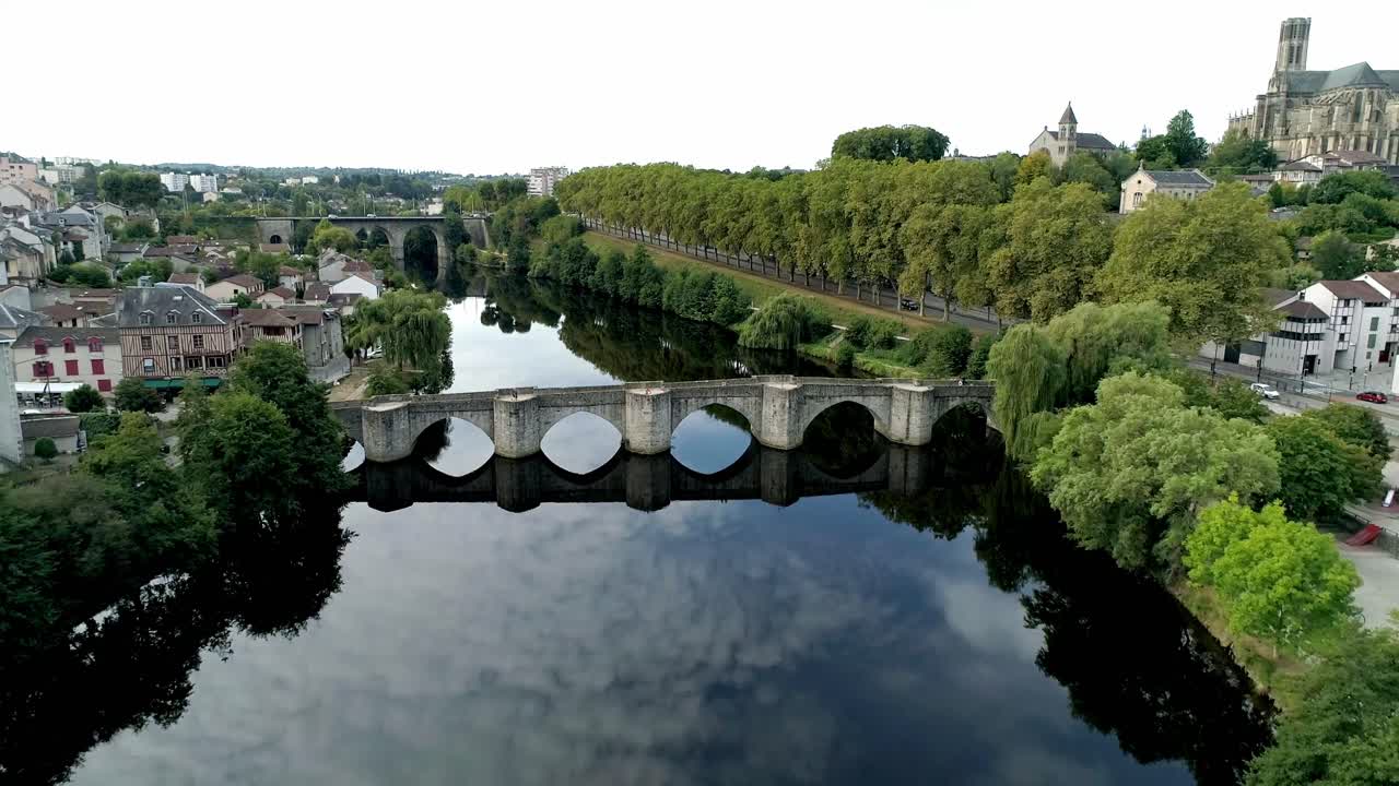 Puente de piedra medieval con sus arcos reflejándose en las tranquilas aguas del río Vienne en Limoges. Vista aérea en picado.