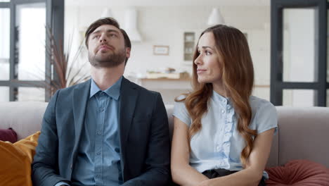 Mujer-Molesta-Quitándole-El-Teléfono-Al-Hombre-En-Casa.-Pareja-Aburrida-Sentada-En-El-Sofá.