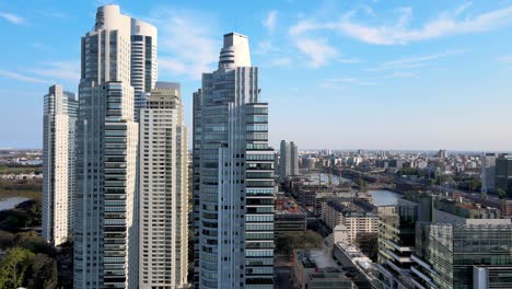 Skyscrapers-and-river-at-Puerto-Madero,-Buenos-Aires,-backward-aerial