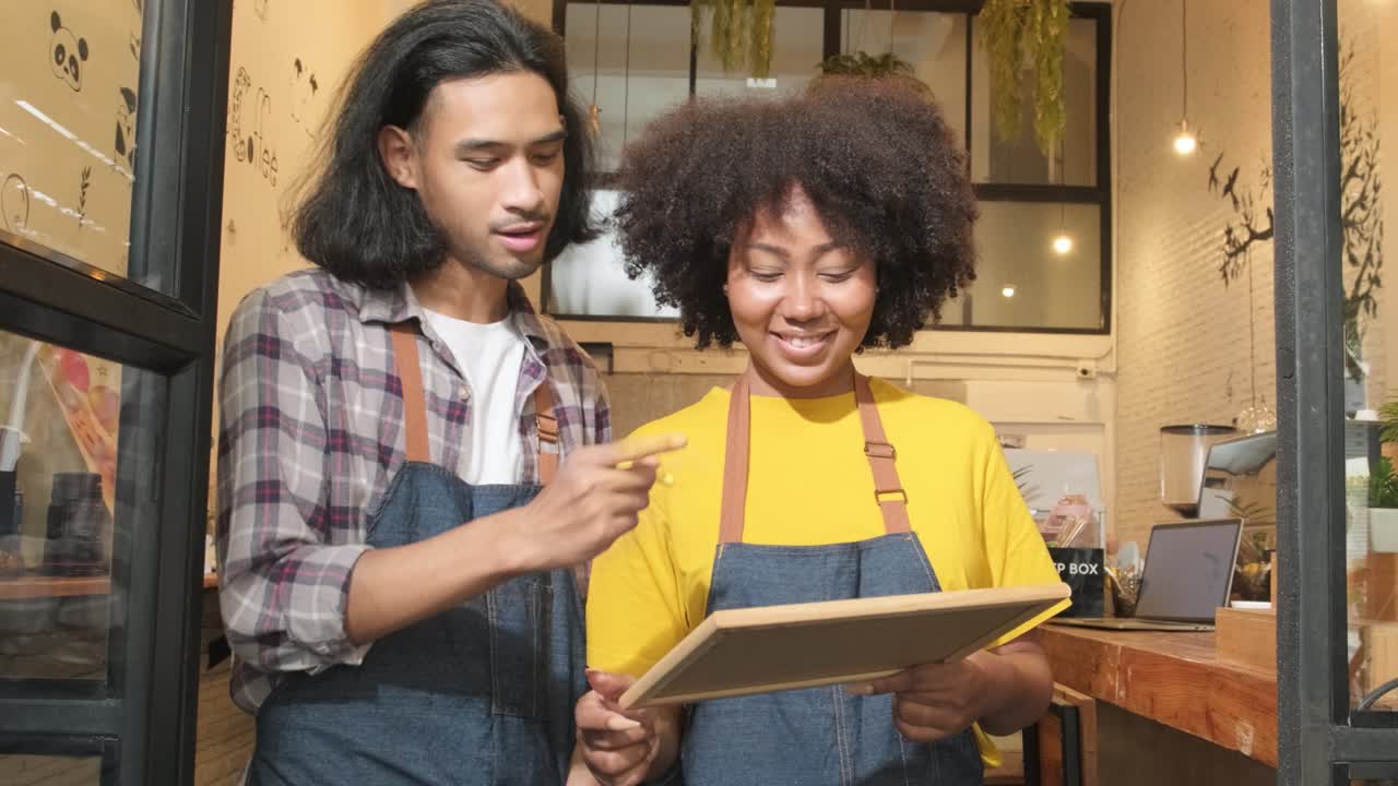dos socios baristas escriben y muestran un letrero abierto, nuevos empresarios.