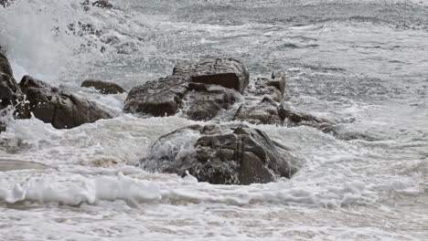 ocean waves crashing against rocks and cliffs on beach in bai bang, con dao, vietnam