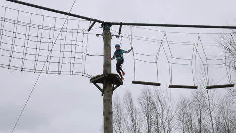 Mädchen-Zu-Fuß-über-Planken-An-Seilen-Auf-Einem-Hochseil-Abenteuer-Hindernisparcours