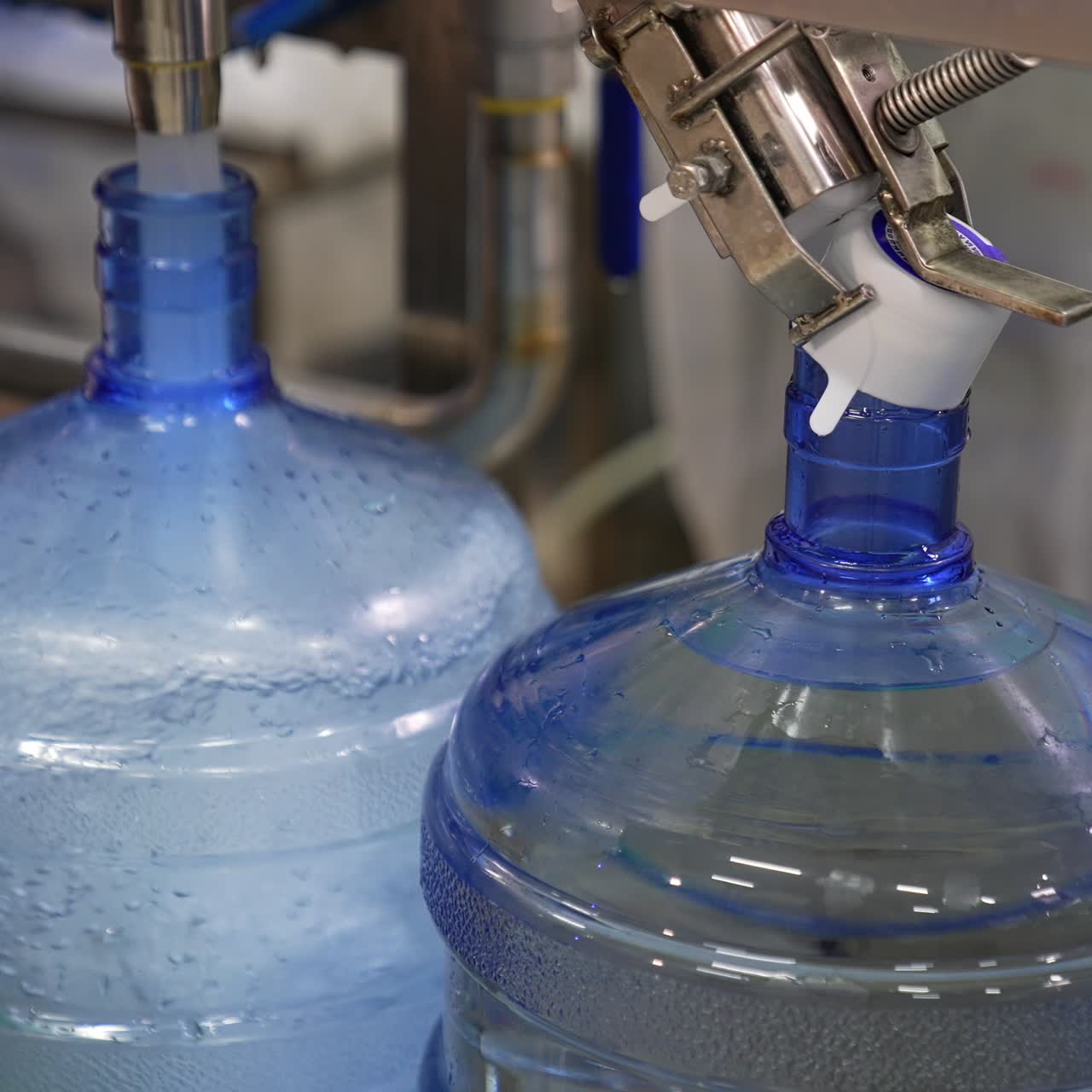 Quick filling of bottles with fresh water. Food factory production. Water supply at manufacture. Close up