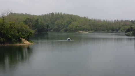 Drohnen-Orbitaufnahme-Eines-Kleinen-Bootes,-Das-Auf-Einem-See-Schwimmt