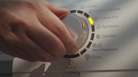 laundry setting washing machine dial to eco mode for energy saving and environmental conservation in bathroom