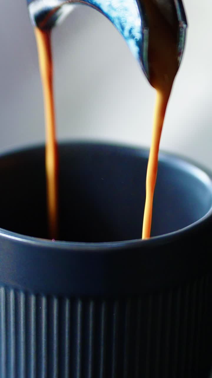 Primo piano di caffè espresso che viene erogato dalla macchina da caffè in una tazza