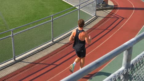 man jogging on the running track - tracking shot