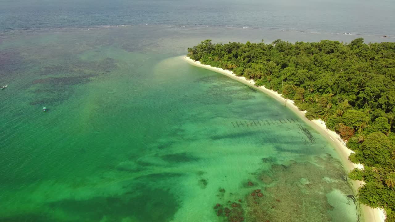 Arrecifes tropicales protegen playas doradas y tranquilas aguas azules, Playa Cahuita, Costa Rica, toma aérea