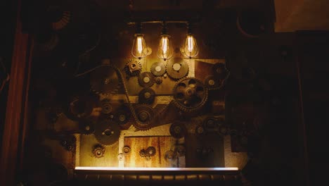 camera moving on wall decorated with mechanism of metallic gears and loft style lamps . interior with industrial  style design . close-up slow motion . flashing lights .