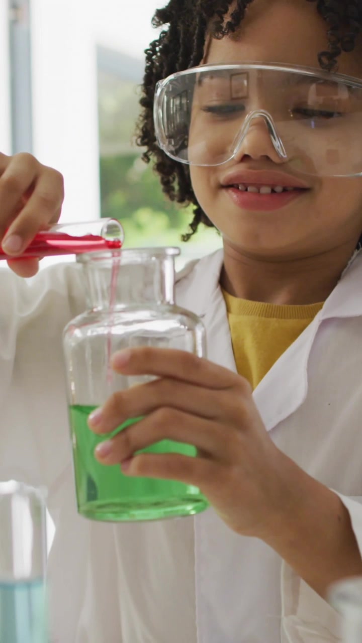 Animation of shapes over african american schoolboy at science class