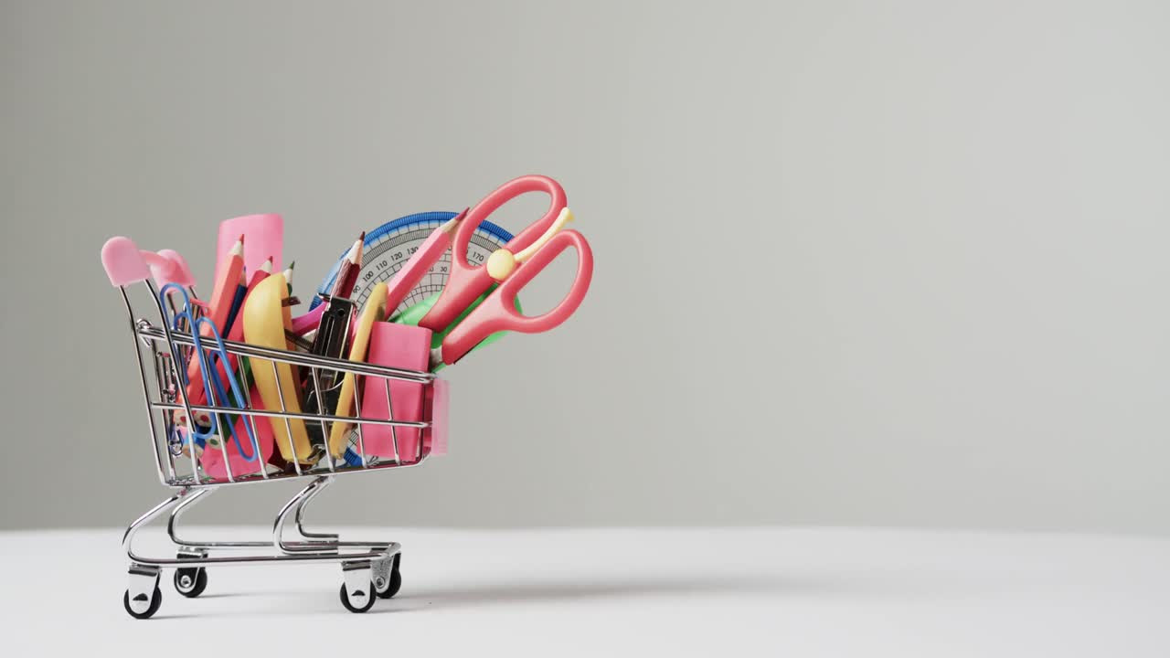 소형 쇼핑 트롤리 학교 자료와 회색 배경에 복사 공간의 클로즈업