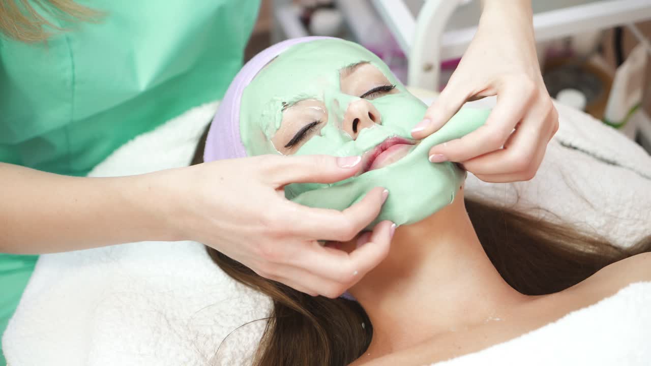 Woman in spa salon. Young beautiful girl with face mask for beauty during spa treatments