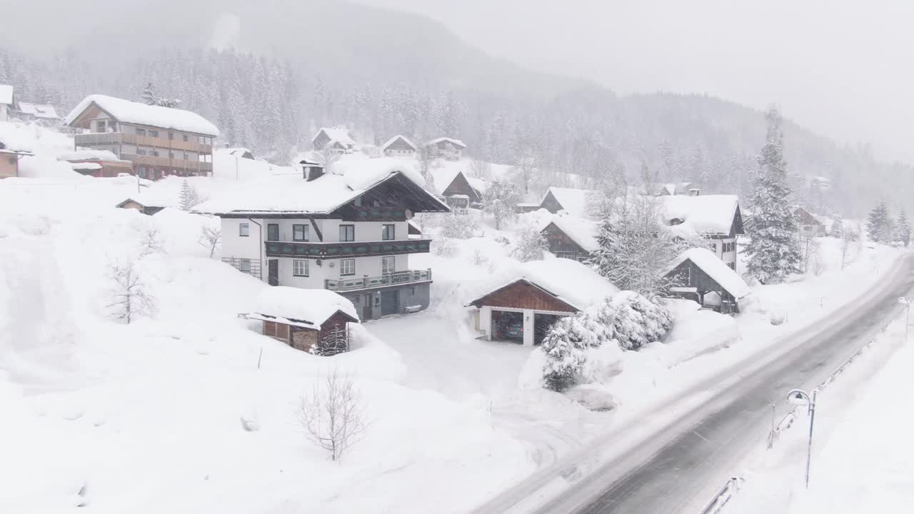 Breeze in Austrian mountains, houses covered in snow. Drone shot,.