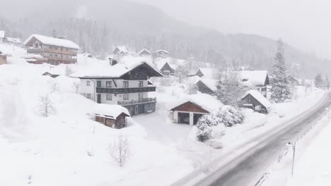breeze in austrian mountains, houses covered in snow. drone shot,.