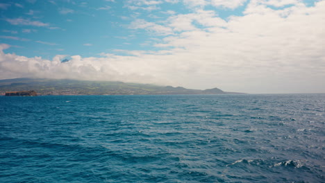 Vista-En-Barco-Del-Pintoresco-Paisaje-Marino-Con-Cielo-Azul-Y-Nubes-De-Ensueño-En-La-Distancia