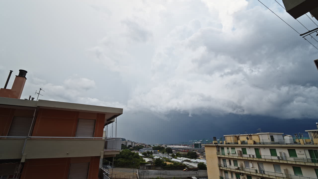 Timelapse of storm clouds moving over urban buildings, dramatic scene