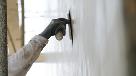 worker applying plaster to a wall with a trowel