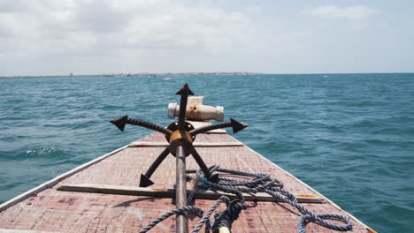 bow deck of seaborne wooden boat with grappling anchor and rope