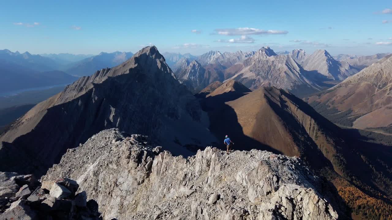 caminante en el borde del acantilado tomando fotos montañas kananaskis alberta columbia británica frontera canadá