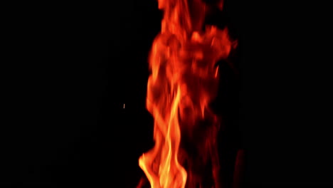 beautiful red fire burning at night. little sparkles fly up from the flame. close up.