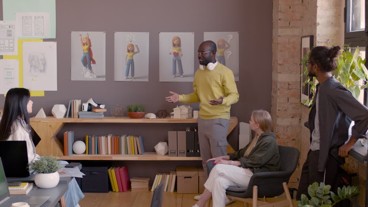 애니메이션 스튜디오에서 동료에게 프로젝트를 설명하는 그래픽 디자이너 1