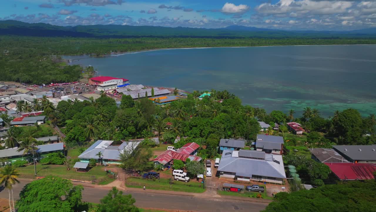 Wewak Hill cars buildings village Boram road Wewak Papua New Guinea aerial drone downtown coastal town Sundaun Market Dogreto Bay Cape Wom Bismark Sea sunny blue sky morning circle right motion