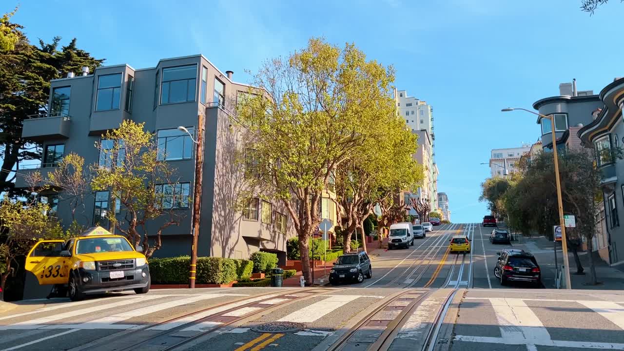 San Francisco, États-Unis, 4 août 2025: Rue escarpée de San Francisco avec des rails de tramway et un taxi. Paysage urbain montrant une route vallonnée avec des rails, une architecture moderne et une voiture jaune.