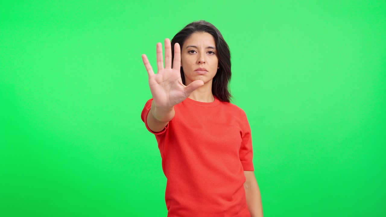 Serious Woman Making Stop Hand Gesture on Green Screen