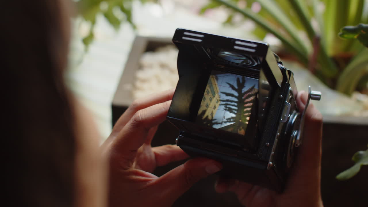 Uomo irriconoscibile che filma un video con una fotocamera retrò