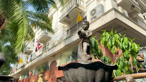 bronze boy fountain statue in front of building