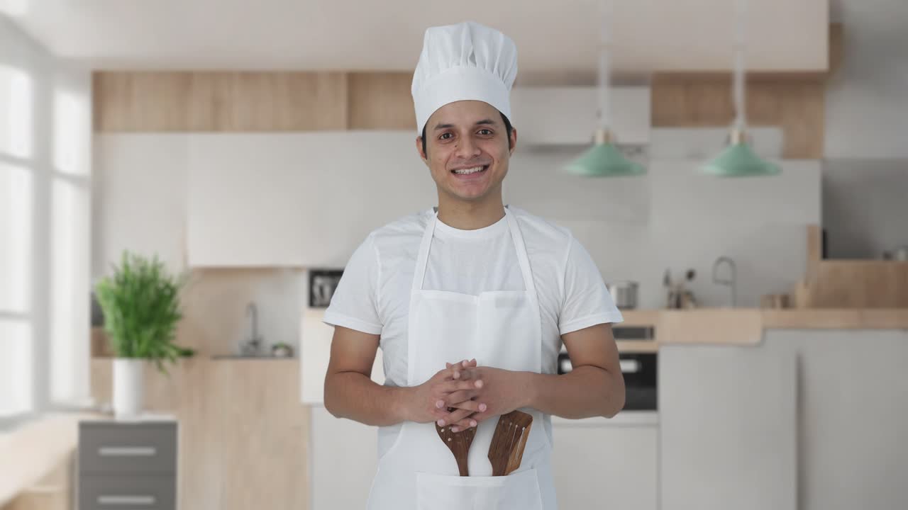 Felice chef professionista indiano che sorride alla telecamera.