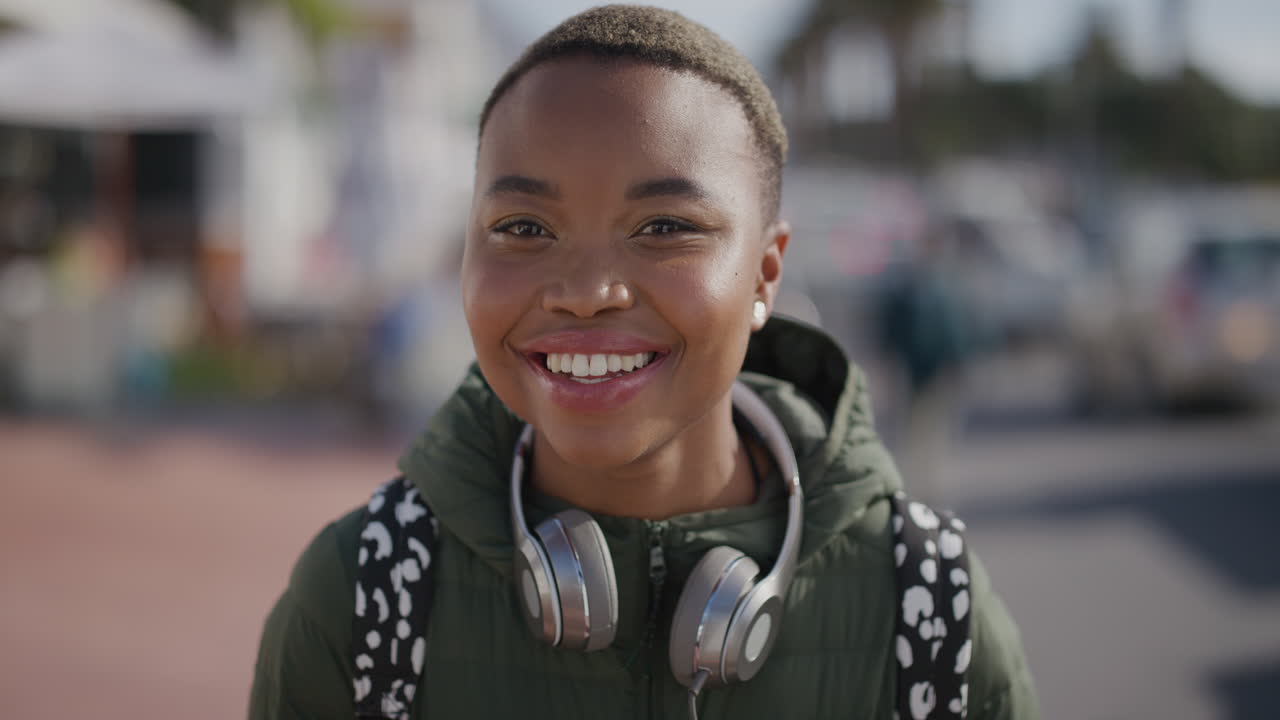 portrait of young beautiful african american woman laughing cheerful wearing headphones