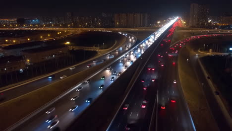 aerial view of busy highway interchange with car light trails at night
