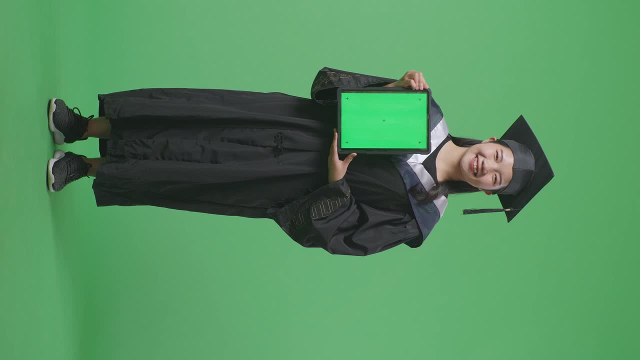 graduado sosteniendo la tableta en la pantalla verde