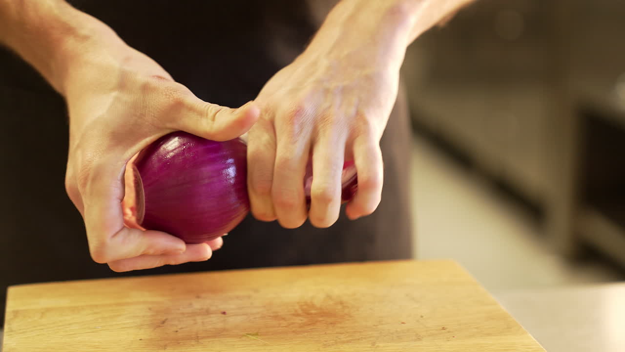 Chef carefully peels onion using clean hands, demonstrating precision and hygiene