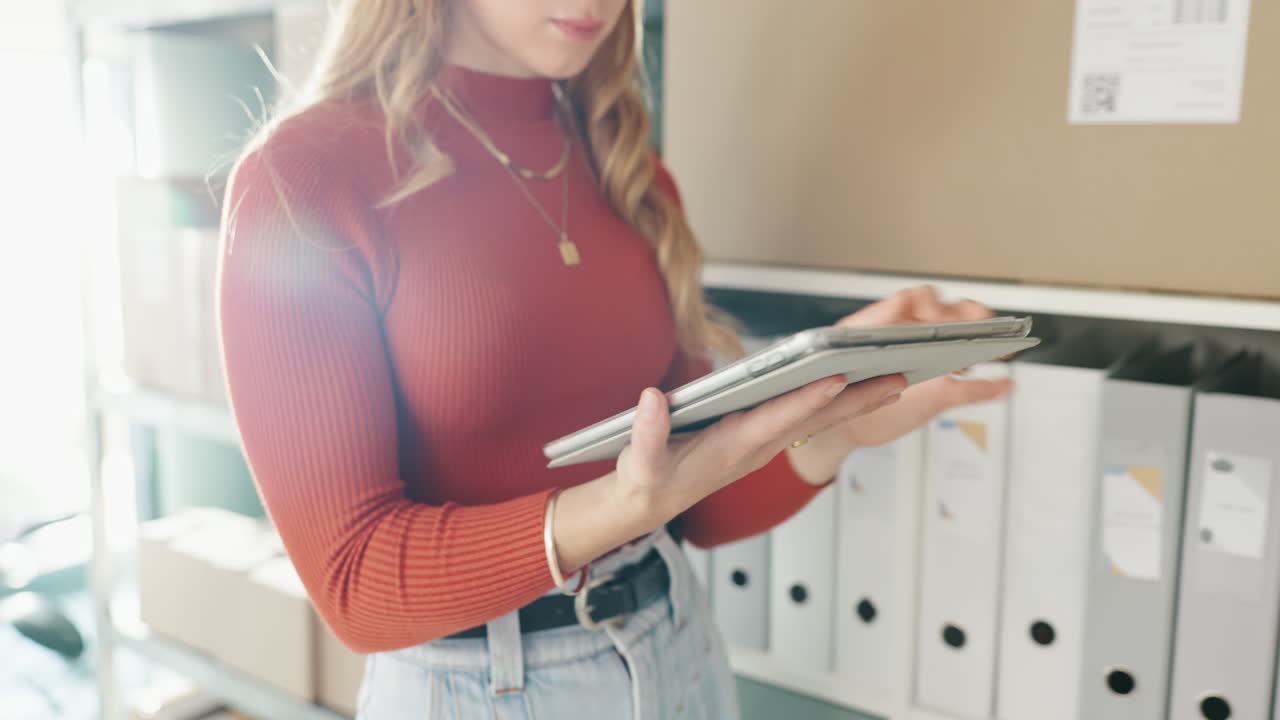 Woman using tablet to manage inventory in warehouse