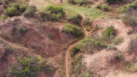 drone vuela sobre tres ciclistas de montaña acercándose en un día soleado