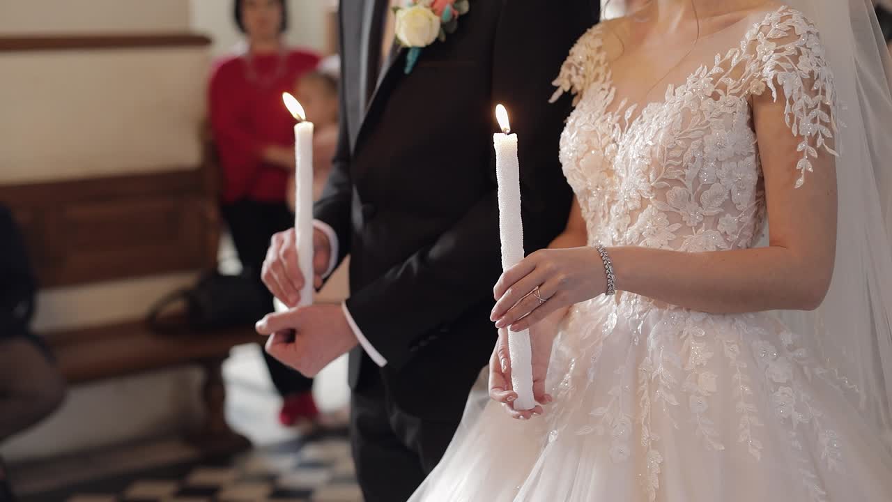 신혼부부. 신랑과 신부 는 교회 에서 손 에 불 을 들고 서 있다