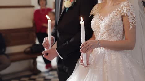 Los-Recién-Casados,-La-Novia-Y-El-Novio,-Están-En-La-Iglesia,-Sosteniendo-Velas-En-Sus-Manos.