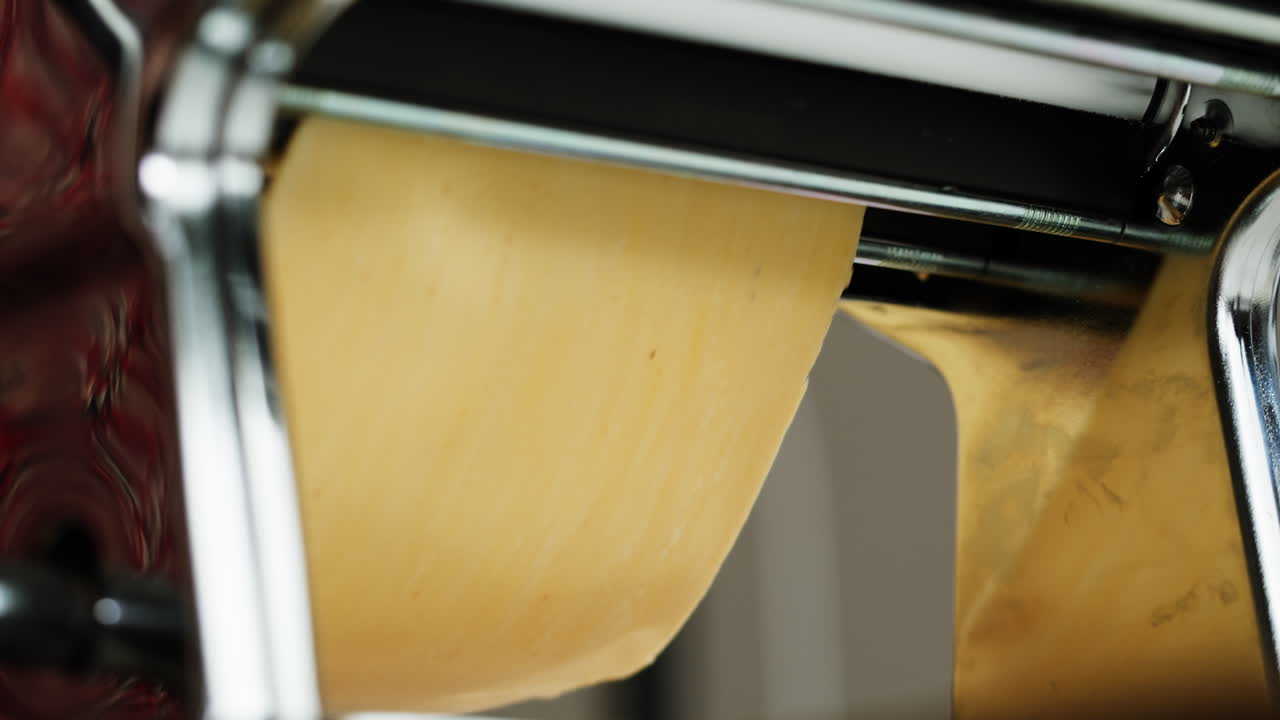 Close-up of Fresh Pasta Dough Being Rolled in a Machine