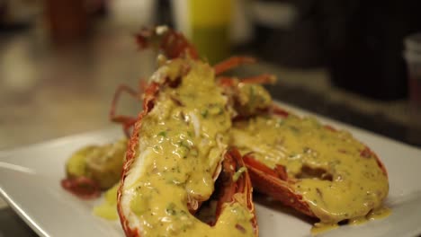 close up - putting a gravy on a cooked new zealand crayfish