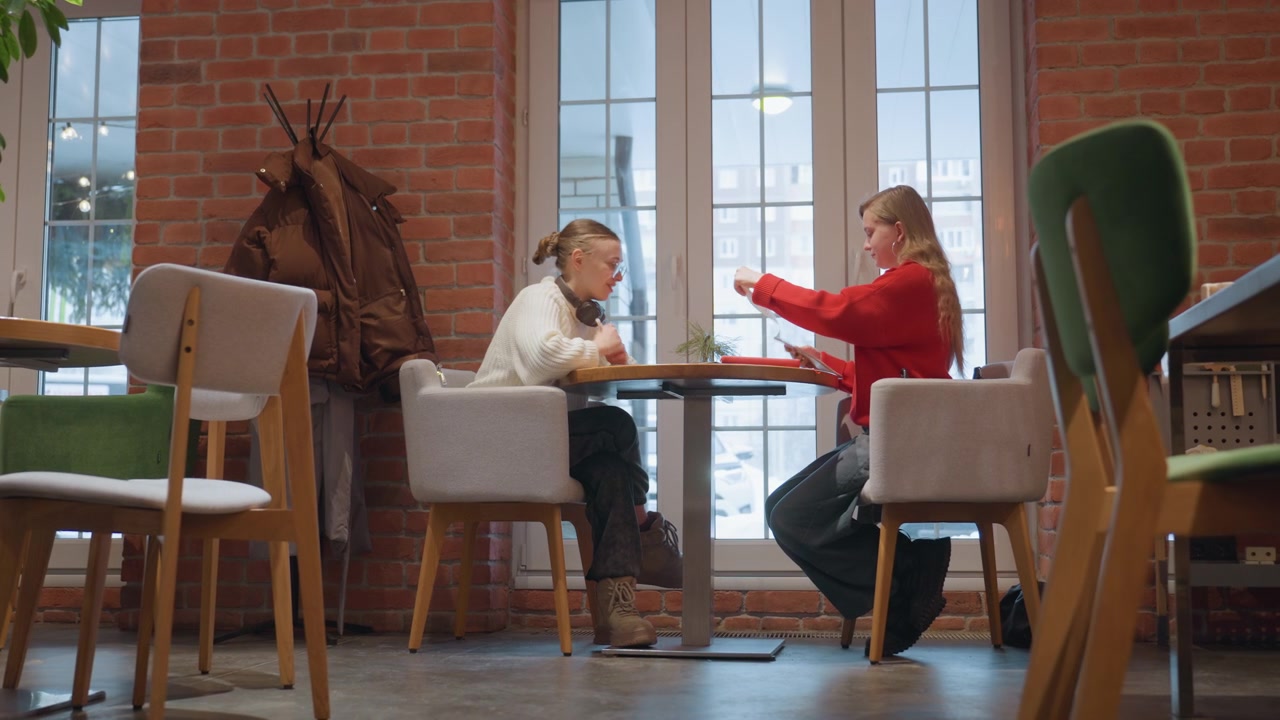 To unge kvinner diskuterer ideer på en moderne kafé