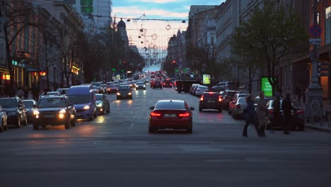 busy city street at dusk with traffic and pedestrians